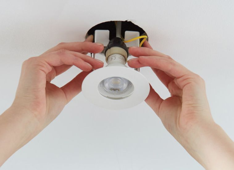 Downlight being installed into ceiling