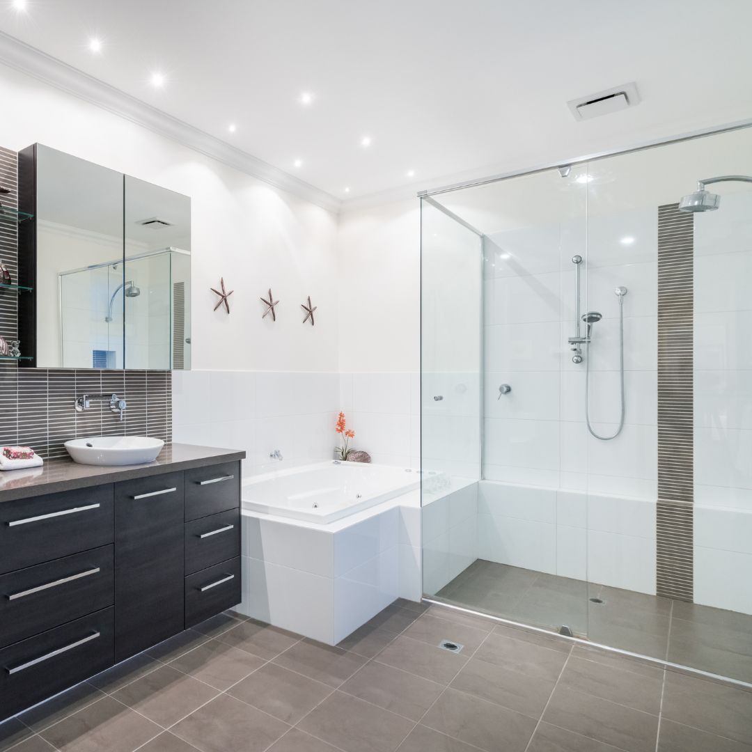 Bathroom with downlights above bath, vanity unit and shower cubicle